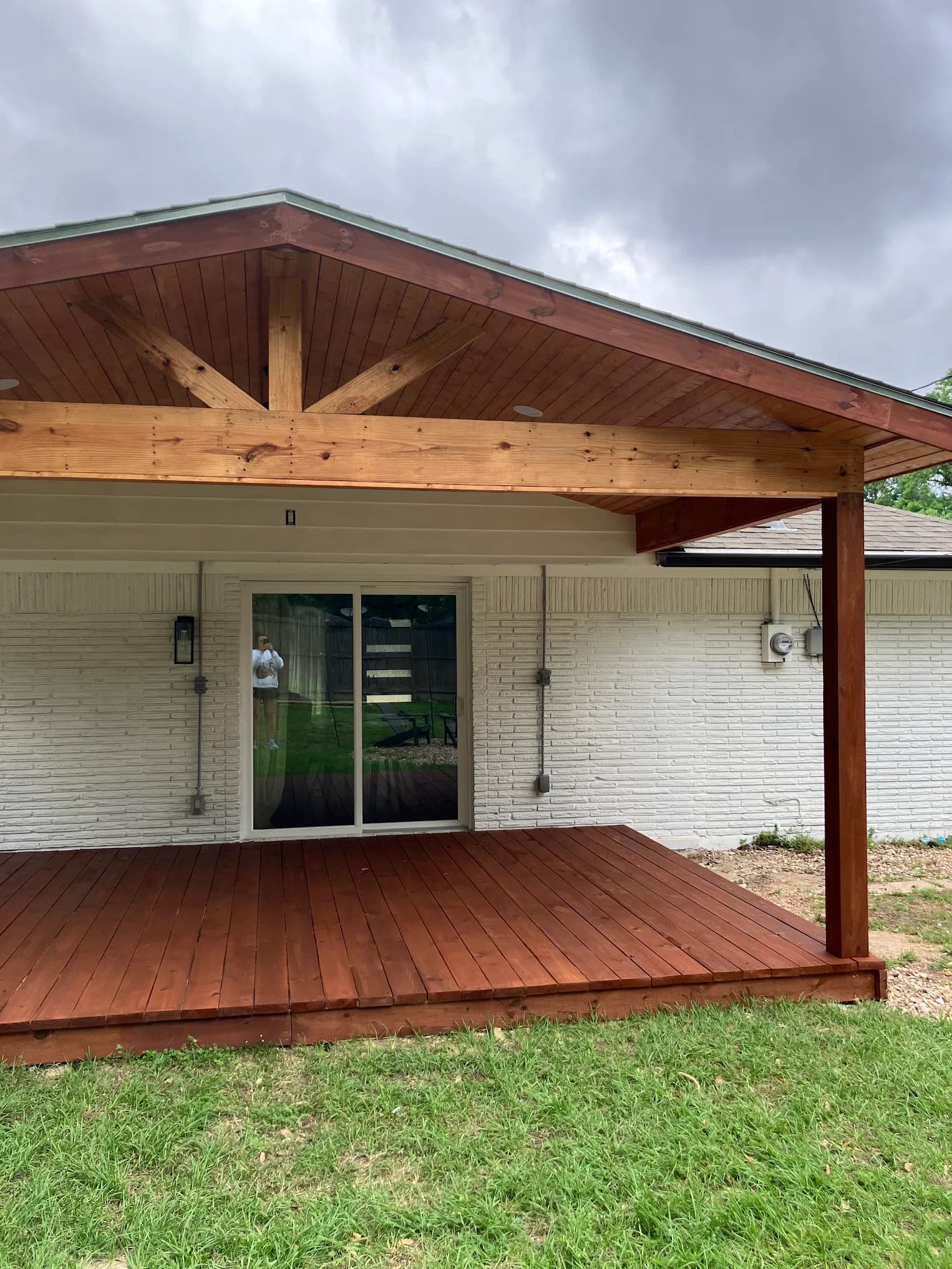 Covered patio with a stained cedar deck and gabled wood ceiling, built by IAS Boutique Remodeling in Houston, TX.