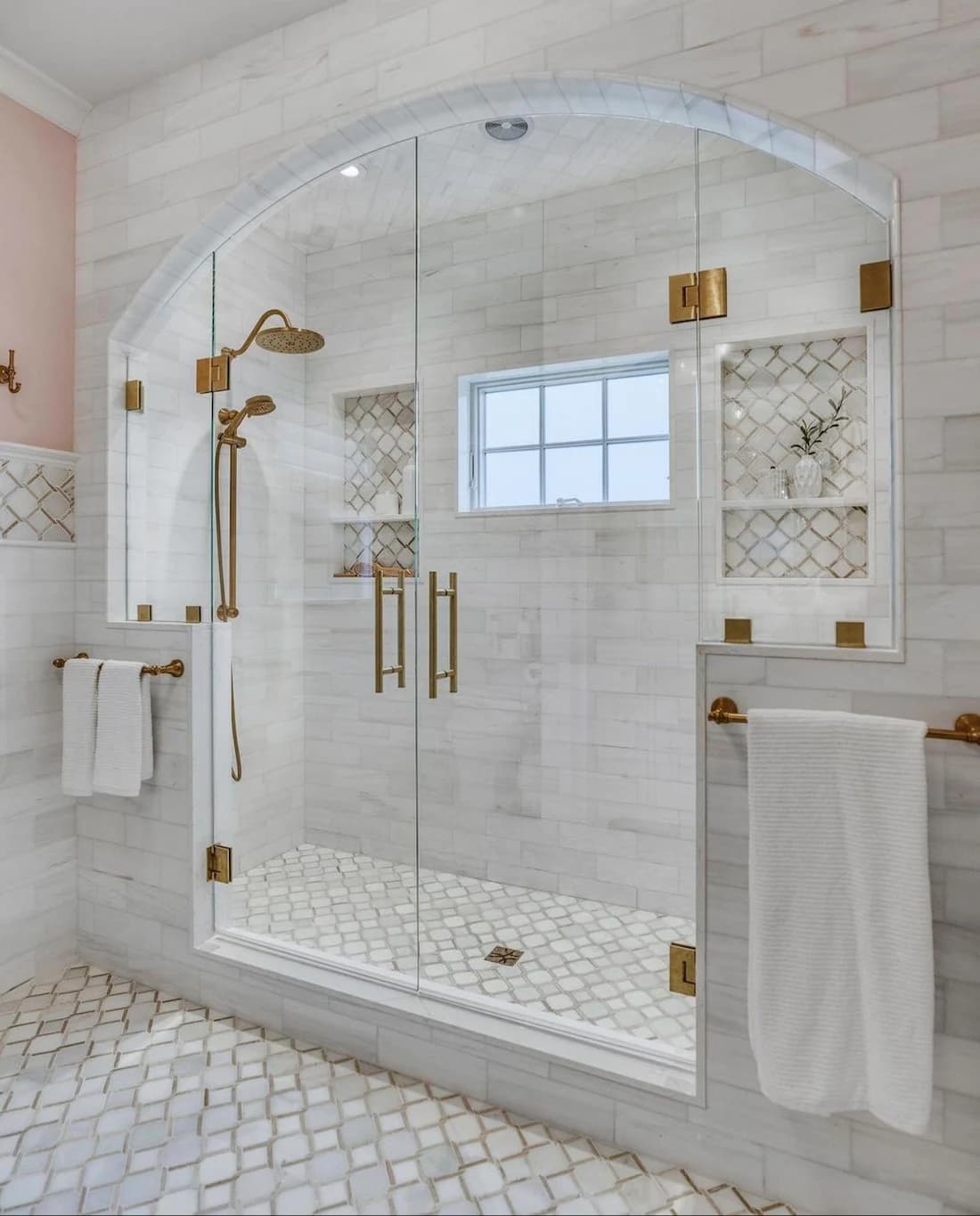 Bathroom remodel by IAS Boutique Remodeling in Houston featuring a marble walk-in shower with an arched glass enclosure.