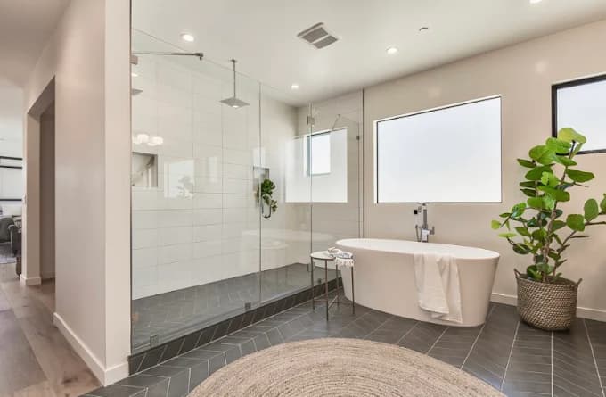 Primary bathroom remodel by IAS Boutique Remodeling in Houston with a freestanding soaking tub and walk-in glass shower.