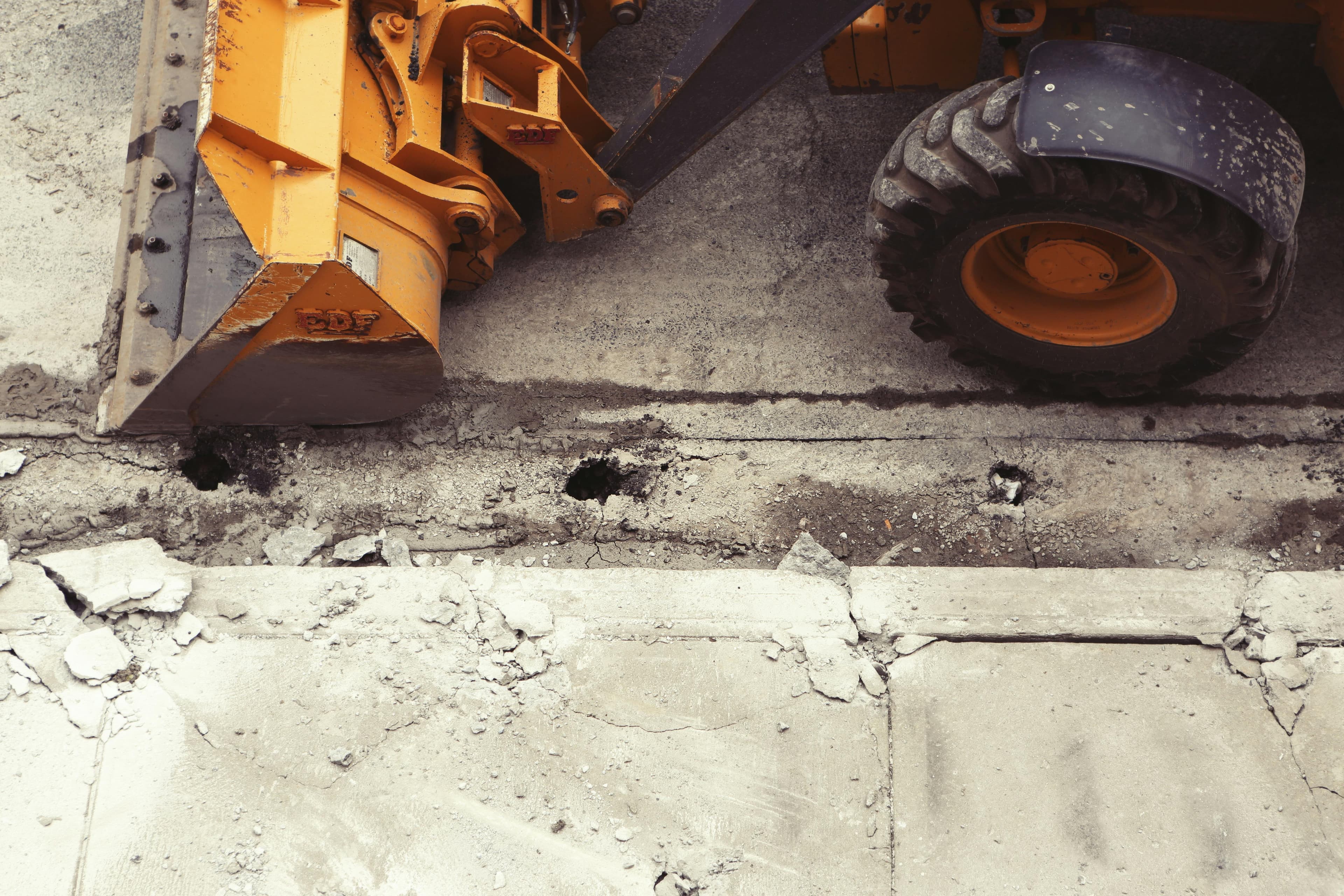 A construction loader and broken concrete at a remodeling demolition site.